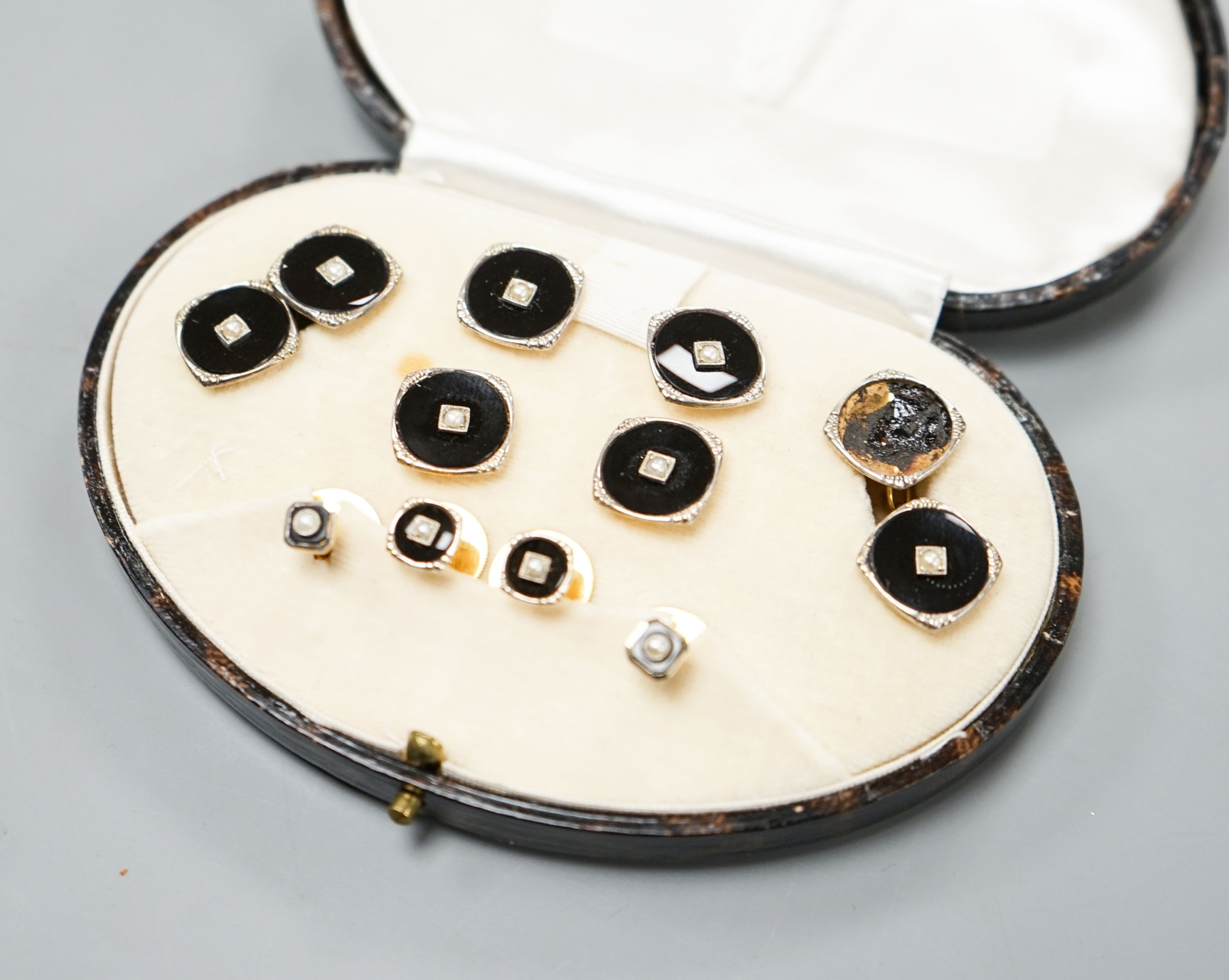 A cases 9ct, black onyx and seed pearl set ten piece dress stud set, gross weight 13 grams (a.f.).